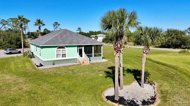 view of front facade with a front yard and a sunroom