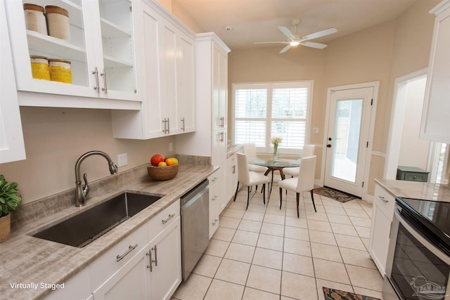 kitchen with sink, light tile patterned floors, ceiling fan, appliances with stainless steel finishes, and white cabinets