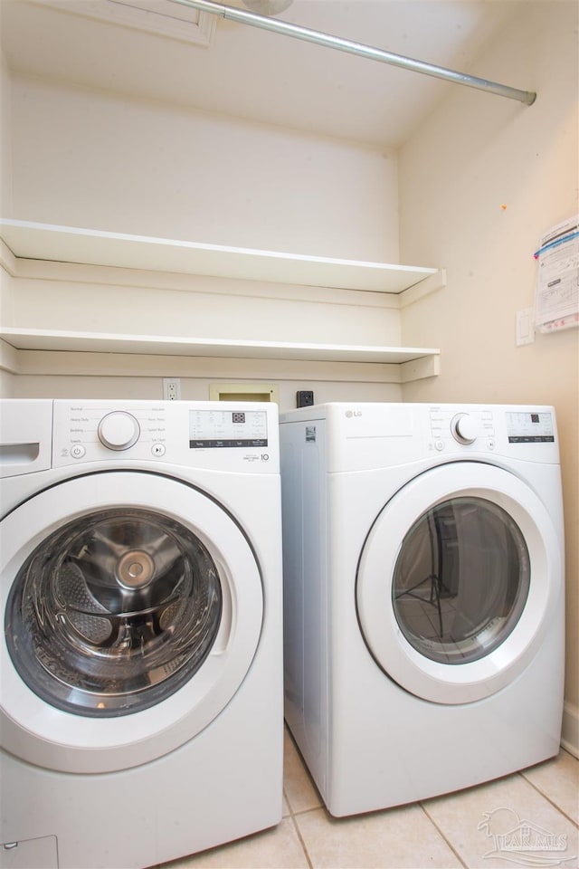 laundry room with light tile patterned flooring and washer and dryer