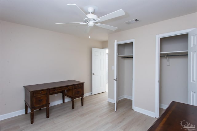 bedroom with multiple closets, ceiling fan, and light hardwood / wood-style floors