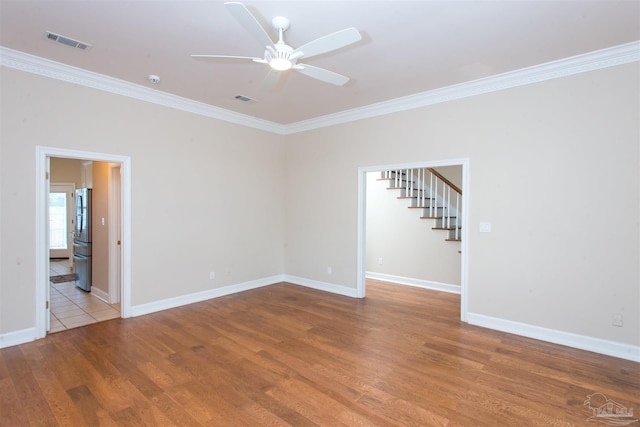 spare room featuring crown molding, wood-type flooring, and ceiling fan