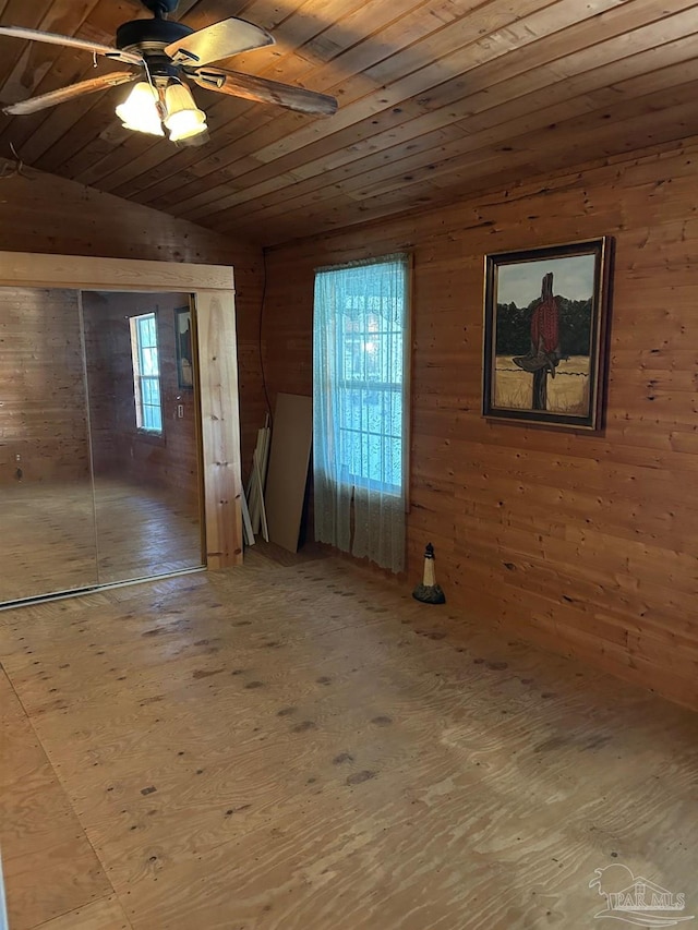 spare room featuring vaulted ceiling, ceiling fan, wood walls, and wood ceiling