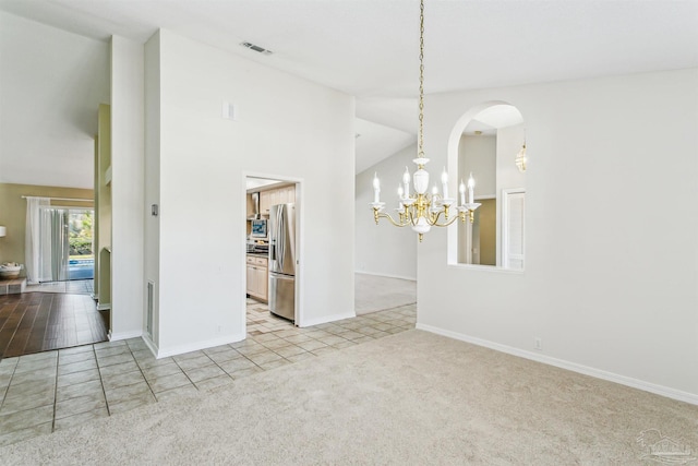 interior space featuring light tile patterned floors, baseboards, an inviting chandelier, arched walkways, and light colored carpet