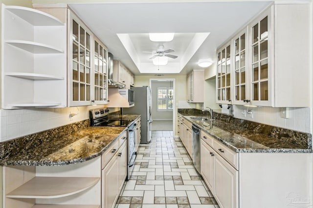 kitchen with open shelves, a sink, tasteful backsplash, stainless steel appliances, and a raised ceiling