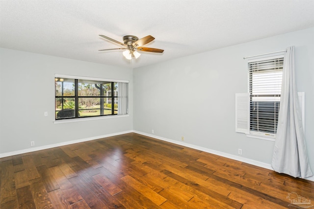 unfurnished room featuring a textured ceiling, baseboards, dark wood-style flooring, and ceiling fan