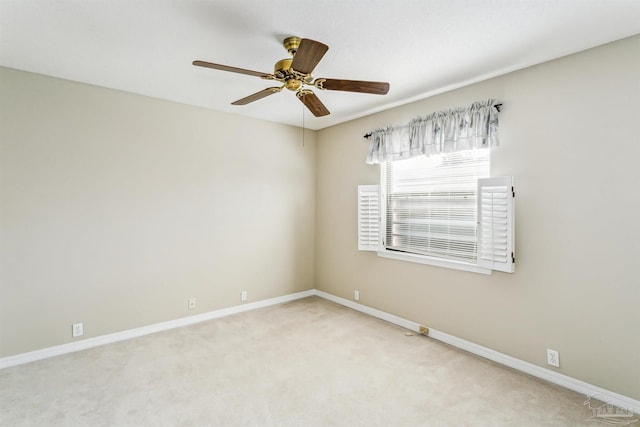 spare room with carpet flooring, ceiling fan, and baseboards