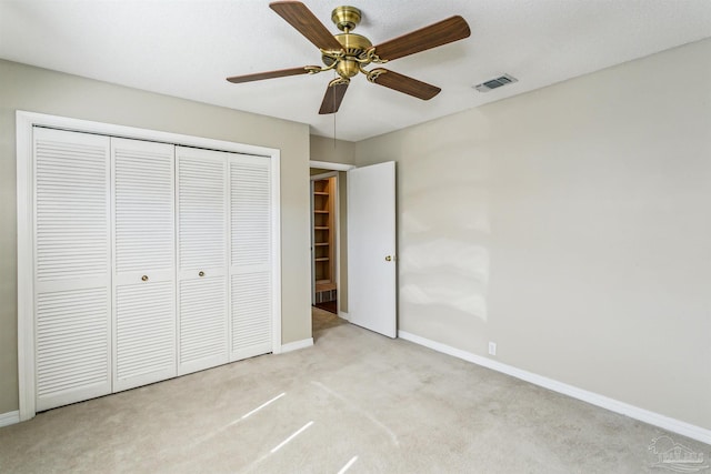 unfurnished bedroom with visible vents, baseboards, carpet, a closet, and a ceiling fan