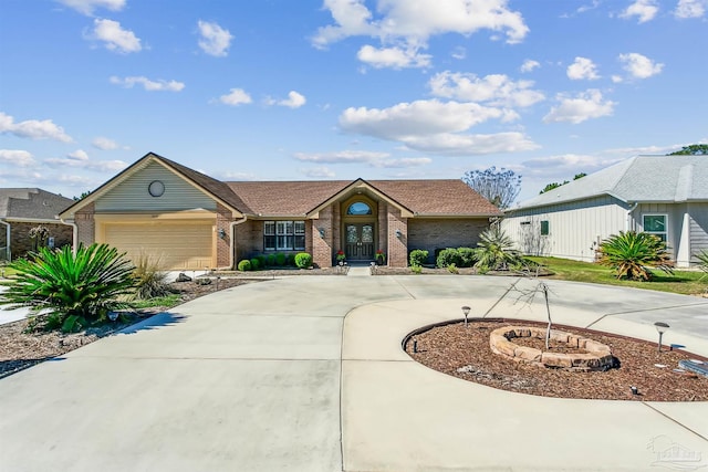 view of front of property featuring an attached garage, brick siding, and curved driveway