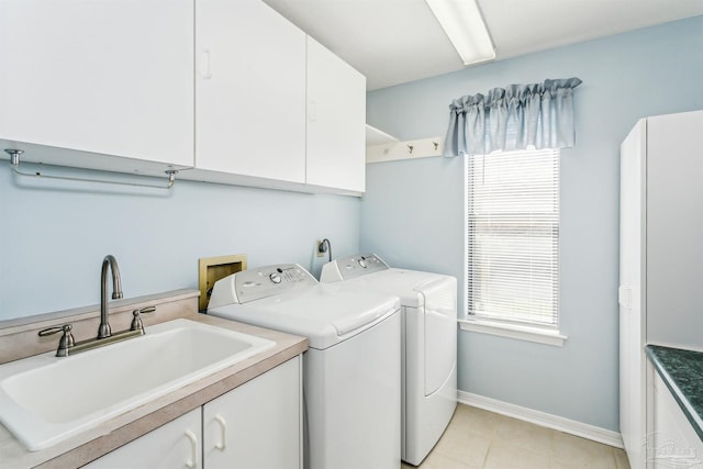 laundry area featuring baseboards, washer and dryer, light tile patterned flooring, cabinet space, and a sink