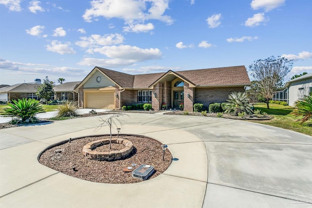 view of front facade featuring a front yard, brick siding, an attached garage, and driveway