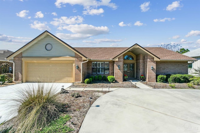 view of front facade featuring brick siding, driveway, a shingled roof, and a garage