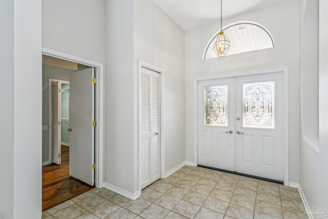 entryway featuring french doors, a high ceiling, and baseboards