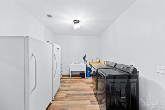 3351 Velor Rd, Mcdavid, FL 32568 - laundry area featuring light wood-type flooring, independent washer and dryer, a sink, visible vents, and laundry area