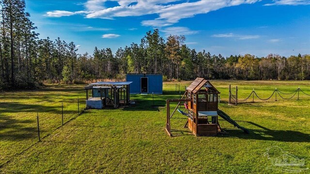 3351 Velor Rd, Mcdavid, FL 32568 - view of play area featuring an outdoor structure, a forest view, and a yard