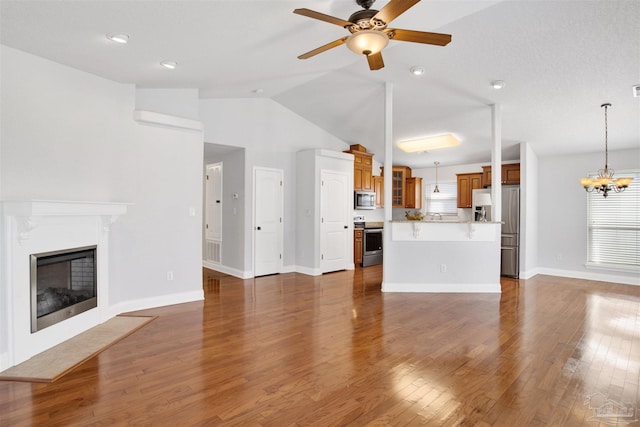 unfurnished living room featuring dark wood-type flooring, lofted ceiling, and ceiling fan with notable chandelier