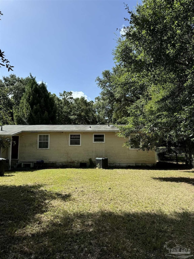 view of side of property with a lawn and central AC