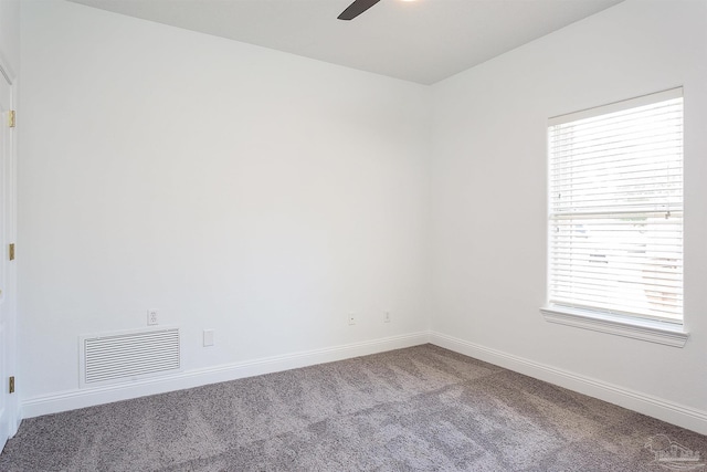 carpeted spare room with baseboards and a ceiling fan