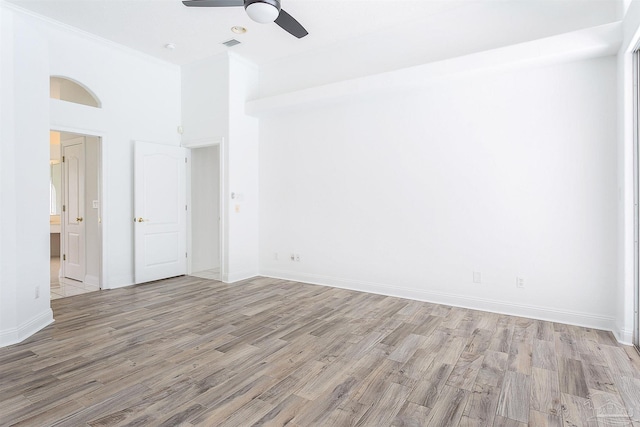unfurnished room featuring light wood finished floors, ceiling fan, and baseboards
