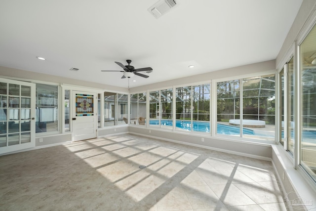 unfurnished sunroom featuring ceiling fan