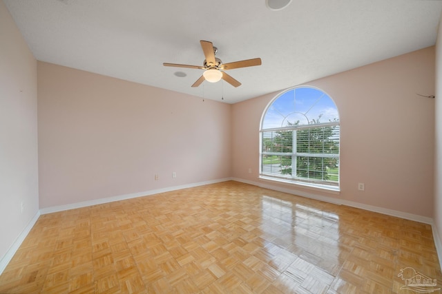 empty room featuring ceiling fan and light parquet floors