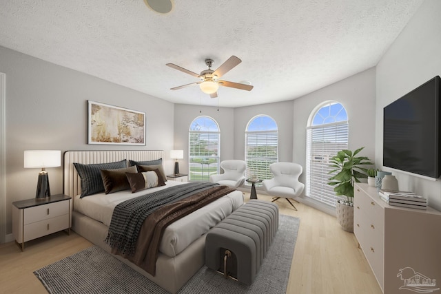 bedroom featuring a textured ceiling, light hardwood / wood-style flooring, and ceiling fan