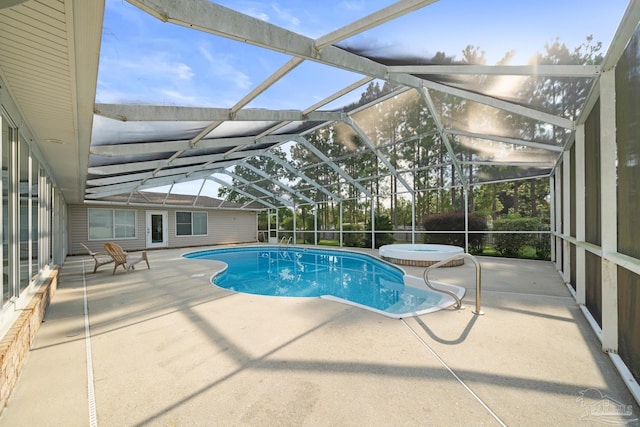 view of pool with a lanai, a patio area, and an in ground hot tub