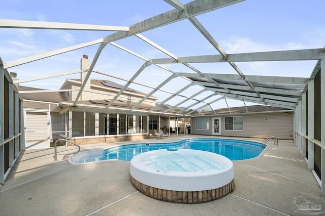 view of pool with an outdoor hot tub, a lanai, and a patio