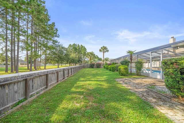 view of yard with a fenced in pool and a lanai