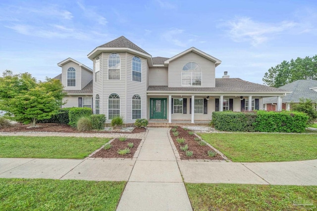 view of front facade featuring covered porch and a front yard