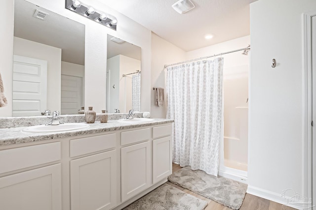4366 White Cedar Ct, Pace, FL 32571 - bathroom with double vanity, a shower with shower curtain, and wood finished floors