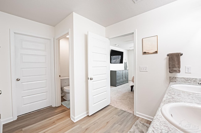 4366 White Cedar Ct, Pace, FL 32571 - full bath featuring wood finished floors, toilet, double vanity, and baseboards