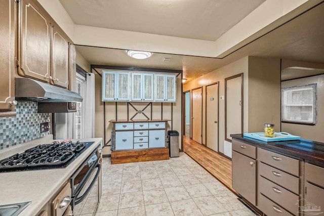 kitchen featuring decorative backsplash, light hardwood / wood-style floors, and stainless steel gas cooktop