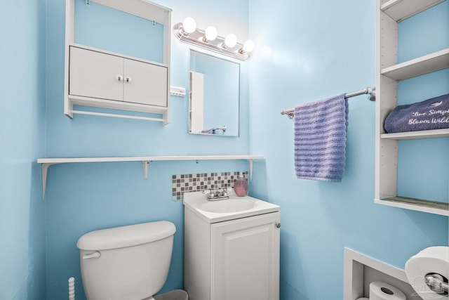 bathroom featuring tasteful backsplash, vanity, and toilet