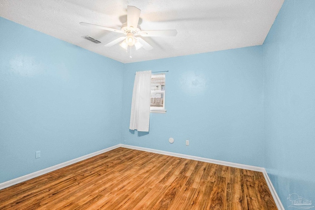 spare room with a textured ceiling, hardwood / wood-style flooring, and ceiling fan