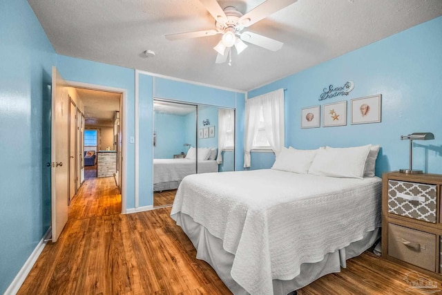 bedroom featuring a textured ceiling, hardwood / wood-style flooring, a closet, and ceiling fan