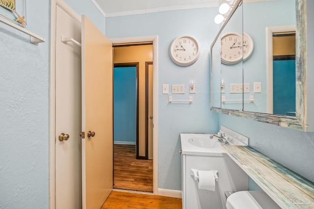 bathroom with hardwood / wood-style flooring, vanity, and toilet