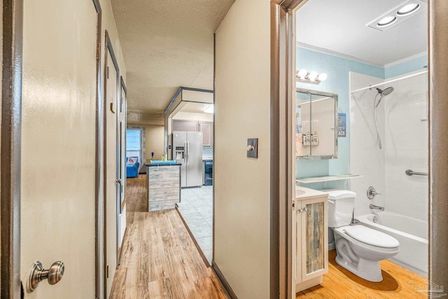 full bathroom featuring tiled shower / bath, toilet, vanity, and hardwood / wood-style flooring