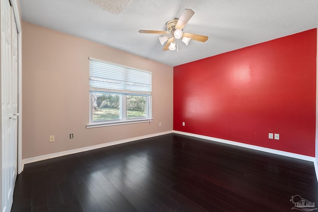 unfurnished room featuring baseboards, a textured ceiling, dark wood-style floors, and a ceiling fan