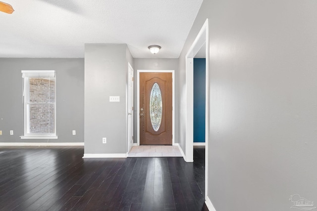 foyer with hardwood / wood-style flooring, baseboards, and a textured ceiling