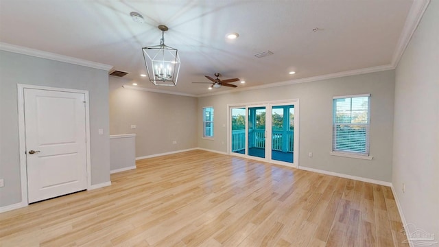 spare room with ceiling fan with notable chandelier, light hardwood / wood-style floors, and crown molding