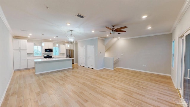 kitchen featuring appliances with stainless steel finishes, a center island, light hardwood / wood-style floors, and pendant lighting