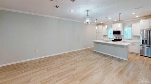 kitchen featuring decorative light fixtures, white cabinetry, appliances with stainless steel finishes, and light hardwood / wood-style flooring