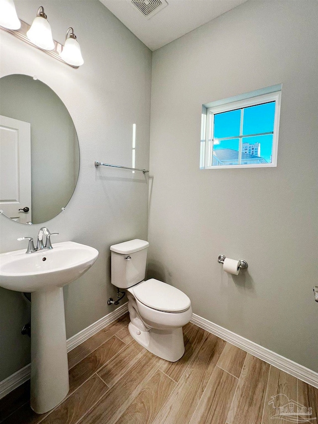 bathroom featuring hardwood / wood-style floors, toilet, and sink