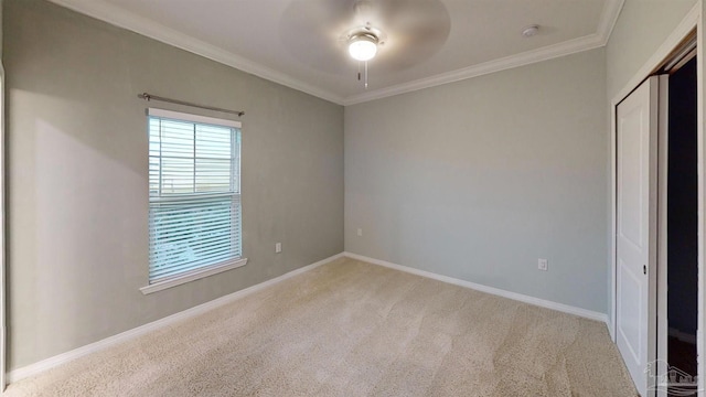 unfurnished bedroom featuring ceiling fan, a closet, light colored carpet, and ornamental molding