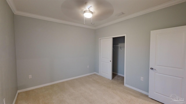 unfurnished bedroom with ceiling fan, a closet, light colored carpet, and ornamental molding