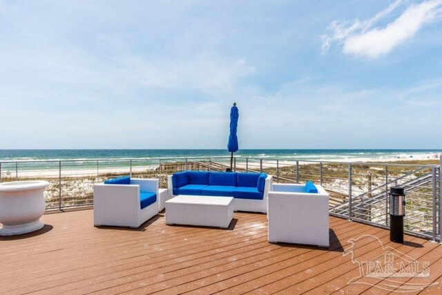 wooden deck with outdoor lounge area, a water view, and a beach view