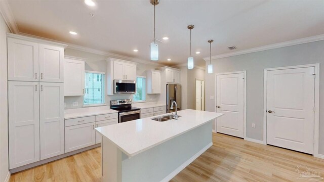 kitchen with white cabinets, hanging light fixtures, sink, light wood-type flooring, and appliances with stainless steel finishes