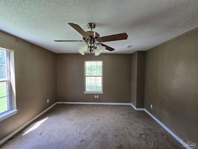 unfurnished room featuring carpet floors, ceiling fan, baseboards, and visible vents