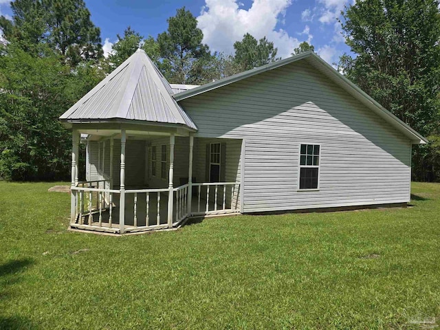 rear view of property featuring a lawn and a porch