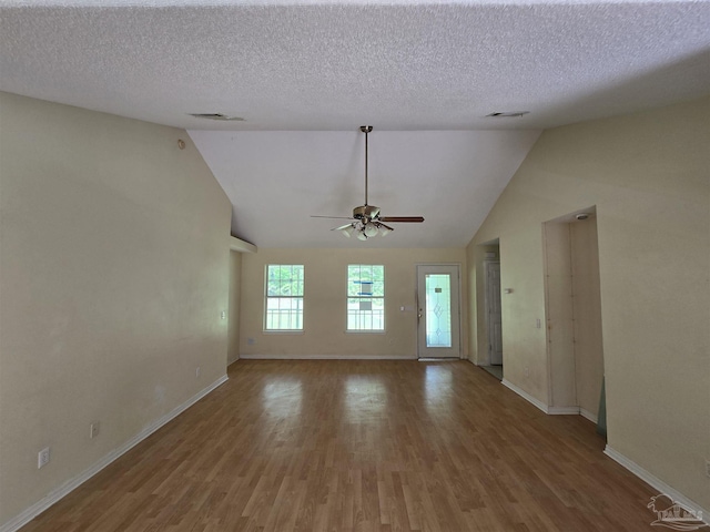 unfurnished living room featuring baseboards, ceiling fan, lofted ceiling, and wood finished floors
